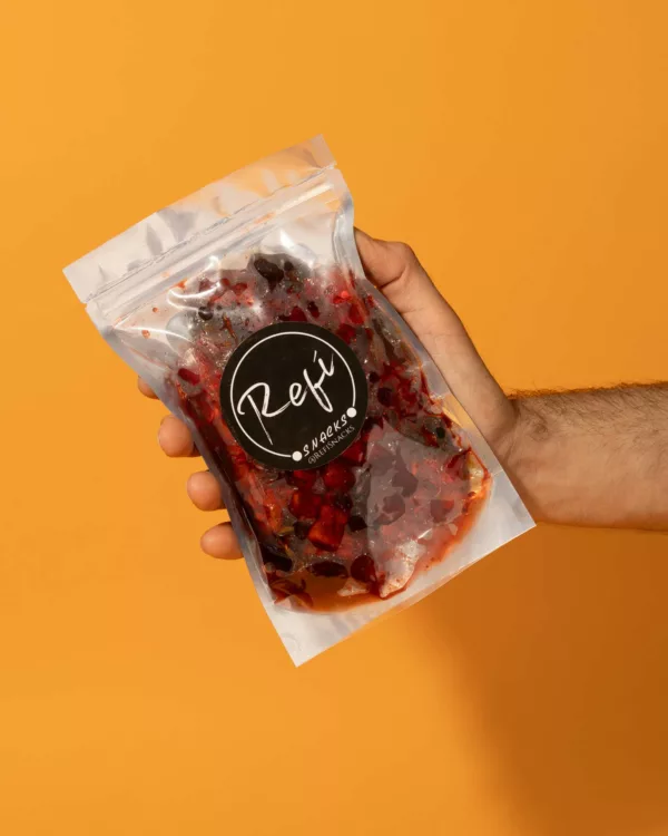 Hand holding a bag of Gummy bears coated with RefiSnacks coated with chamoy paste.